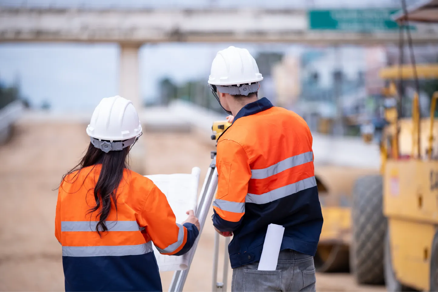 Design and construct professionals reviewing plans on a construction site